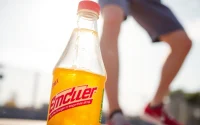 Enjoy a refreshing sportsdrink with vibrant labels and cooling droplets on a sunny day.