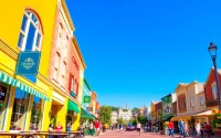 Clarksburg's lively downtown scene with colorful storefronts and bustling pedestrians enjoying the day.